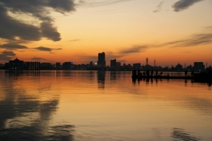 霞ケ浦湖面に写る夕映えとワカサギ釣り客。遠く土浦市街地