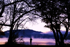 日の出前の中禅寺湖畔。木々が額縁みたいに、湖水と朝もやを映しています