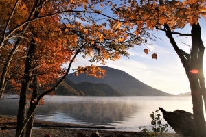 カエデの紅葉と美しい湖水をバックに、雄大な日光男体山が聳えます。