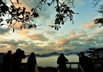 展望台から朝霧雲海を望む観光客。うろこ雲が朝焼け色に染まる朝の絶景