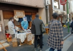 商店街が自分の店の前で営業中。